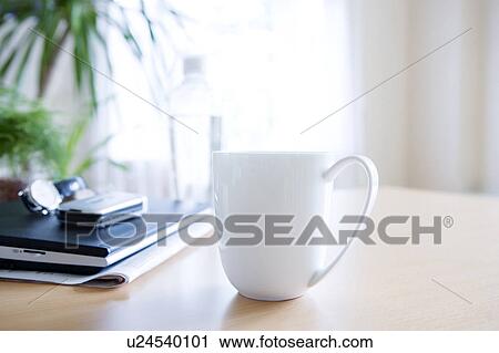 Stock Image - Laptop and mug on a table. Fotosearch