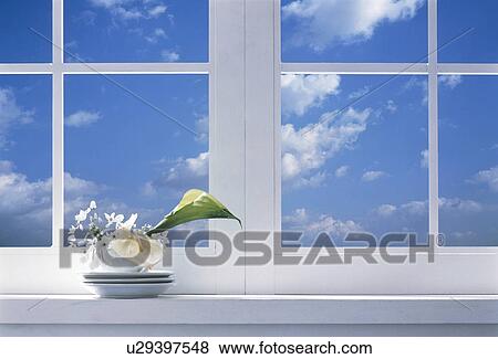 Stock Photo - Lily in a mug on a windowsill. Fotosearch