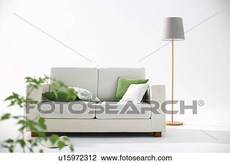 Stock Image - Living room with sofa, lamp and potted plant. Fotosearch