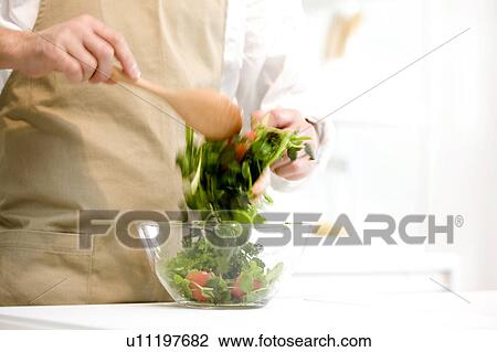 Stock Image - Man making salad. Fotosearch