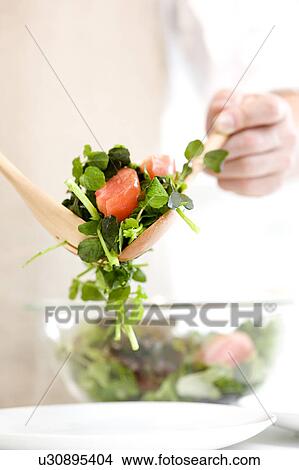 Picture - Man serving salad. Fotosearch