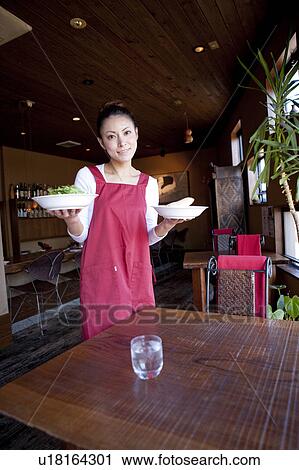 Mid Adult Woman Holding Dishes at Table View Large Photo Image Stock Image - Mid Adult Woman Holding Dishes at Table. Fotosearch