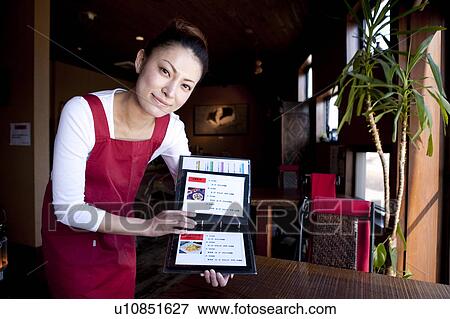 Stock Photo - Mid Adult Woman Showing Menu at Table. Fotosearch