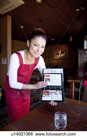 Mid Adult Woman Showing Menu at Table View Large Photo Image Stock Photograph - Mid Adult Woman Showing Menu at Table. Fotosearch