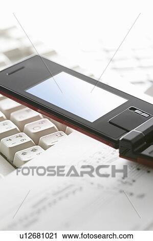 Stock Image - Mobile phone, musical score and computer keyboard. Fotosearch