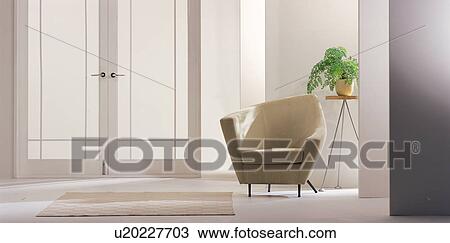 Stock Image - Modern chair with a pot plant on a table by a door. Fotosearch