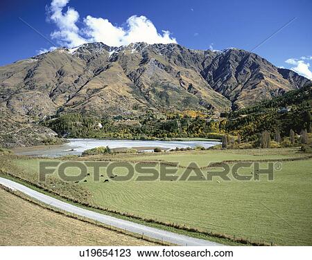 Stock Image - Mountain, beach and farmland, Queenstown, South Island, New Zealand. Fotosearch