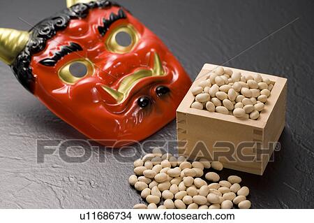 Picture - Oni mask and bamboo box of roasted soybeans for Setsubun. Fotosearch