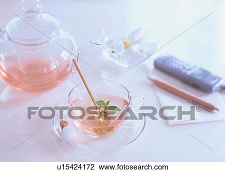 Stock Image - Peach and apricot tea on table next to mobile phone and pen. Fotosearch
