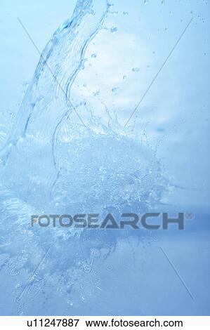 Stock Photo - Pouring water, blue background. Fotosearch
