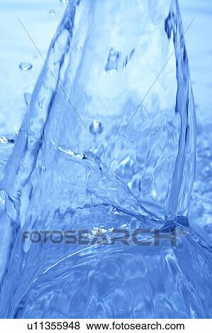 Stock Photo - Pouring water, close up, blue background. Fotosearch