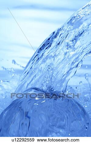 Stock Photo - Pouring water, close up, blue background. Fotosearch