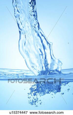 Stock Photo - Pouring water, close up, blue background. Fotosearch