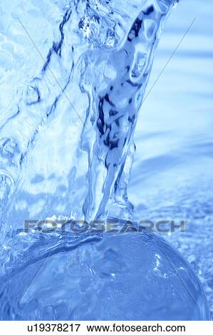 Stock Photo - Pouring water, close up, blue background. Fotosearch