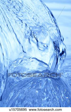 Stock Photography - Pouring water, close up, blue background. Fotosearch