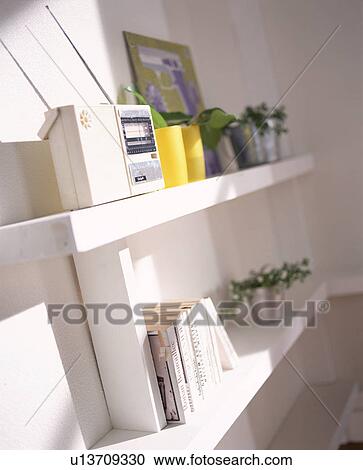 Stock Image - Radio on shelf with books and potted plants. Fotosearch