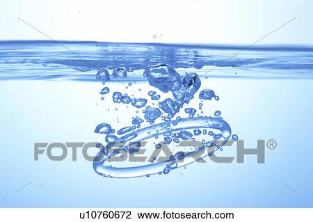 Stock Image - Ring dropped in water, blue background. Fotosearch