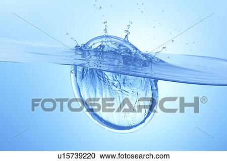 Stock Image - Ring dropped in water, blue background. Fotosearch