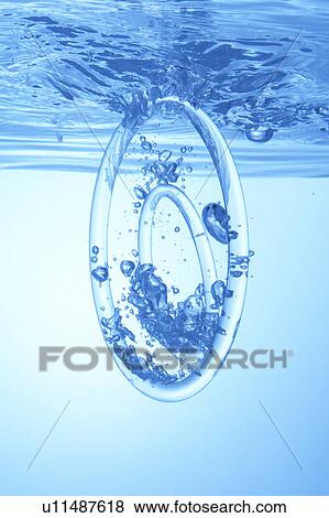 Stock Photo - Rings dropped in water, blue background. Fotosearch