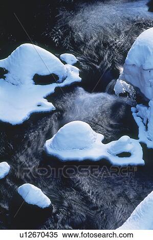 River flowing past mounds of snow on rocks View Large Photo Image Stock Photography - River flowing past mounds of snow on rocks. Fotosearch