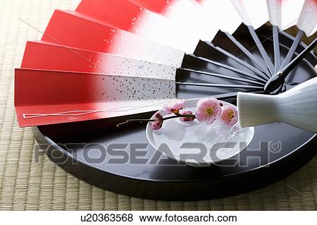 Stock Photo - Sake and a folding fan on a tray. Fotosearch