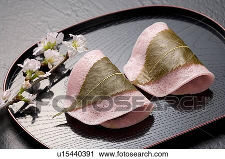 Stock Image - Sakuramochi on a tray with cherry blossom branch. Fotosearch