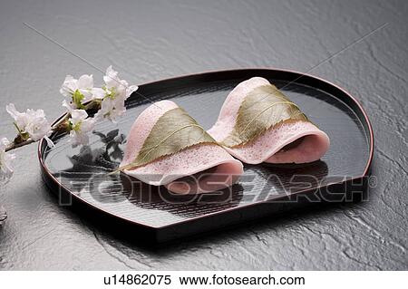 Stock Photography - Sakuramochi on a tray with cherry blossom branch. Fotosearch