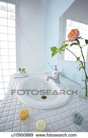 Stock Photo - Sink in bathroom with rose in vase and bars of soap. Fotosearch