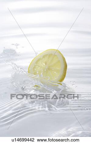 Slice of lemon dropped in water, white background View Large Photo Image Stock Image - Slice of lemon dropped in water, white background. Fotosearch