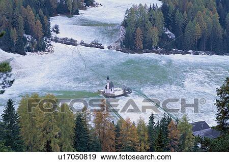 Stock Photo - Small church in a snowy field. Dolomites, Italy. Fotosearch