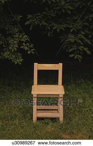 Stock Photo - Small wooden chair next to tree. Fotosearch
