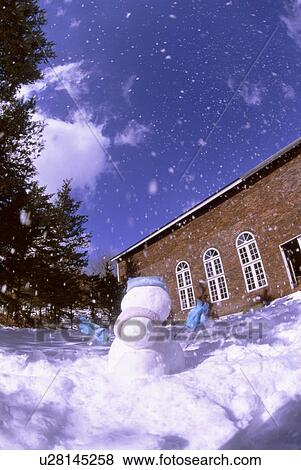 Stock Photo - Snow falling around a snowman. Fotosearch