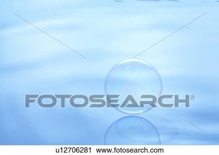 Stock Image - Soap bubble on water surface, blue background. Fotosearch