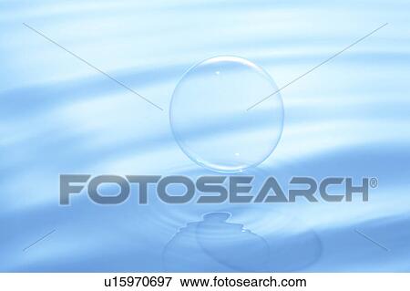 Stock Photo - Soap bubble on water surface, blue background. Fotosearch