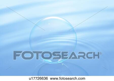 Stock Photograph - Soap bubble on water surface, blue background. Fotosearch