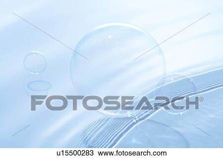 Stock Image - Soap bubbles on water surface, blue background. Fotosearch