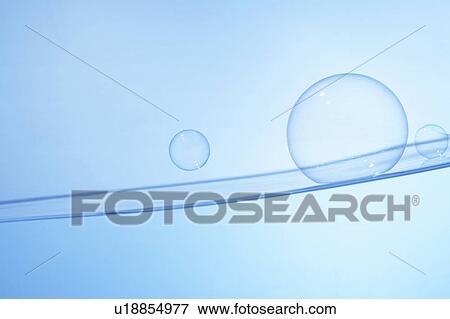 Stock Photo - Soap bubbles on water surface, blue background. Fotosearch
