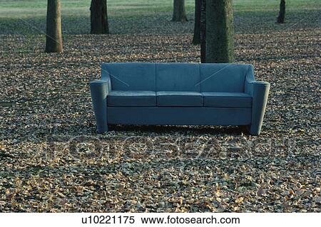 Stock Photography - Sofa amid fallen autumnal leaves. Fotosearch