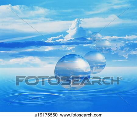 Stock Image - Spheres floating on rippled water under a blue sky. Fotosearch