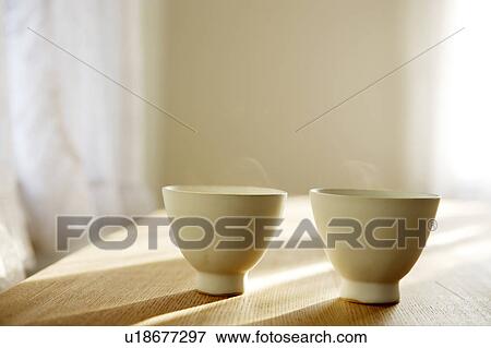 Steaming teacups on a table View Large Photo Image Stock Photo - Steaming teacups on a table. Fotosearch