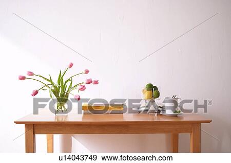 Stock Photo - Table with crockery and pink tulips in vase. Fotosearch
