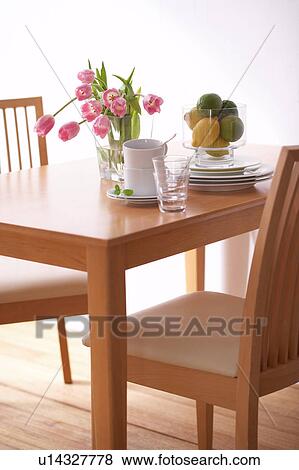 Stock Photo - Table with crockery and pink tulips in vase. Fotosearch