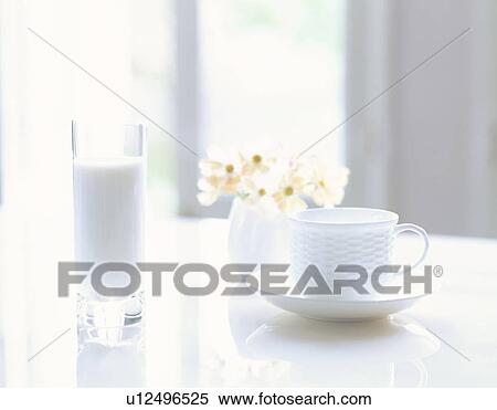 Stock Photography - Tea cup on table next to glass of milk. Fotosearch