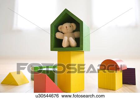 Stock Photograph - Teddy bear inside a wooden block. Fotosearch
