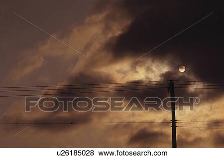 Stock Photo - Telephone pole silhouetted by the moon. Fotosearch