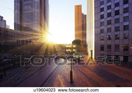 Stock Image - The Shinjuku high-rise complex and the setting sun, Shinjuku-ku, Tokyo, Japan. Fotosearch