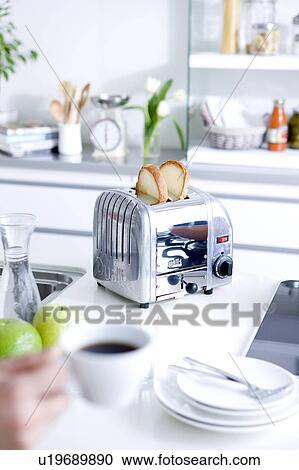 Toaster on kitchen counter and hand holding coffee cup View Large Photo Image Stock Image - Toaster on kitchen counter and hand holding coffee cup. Fotosearch