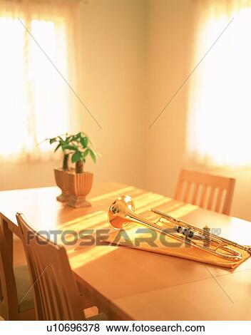 Stock Photo - Trumpet and money tree on dining room table. Fotosearch