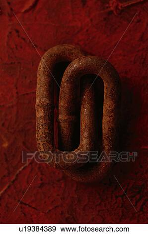 Stock Photo - Two rusty chain links on red textured background. Fotosearch