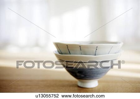 Stock Image - Two teacups stacked on a table. Fotosearch